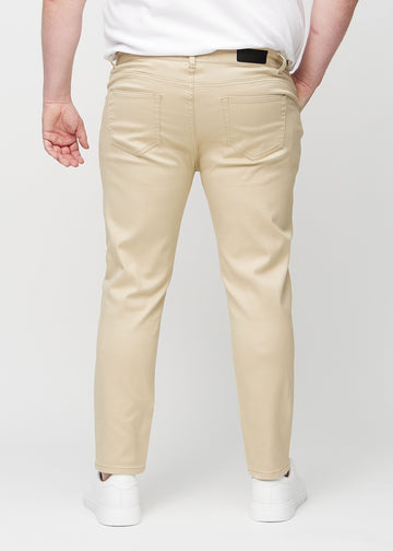 Beige jeans i slim fit sett bakfra på en plus-size-modell for å vise hele produktet.