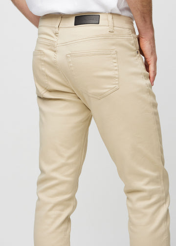 Nærbilde bakfra av beige jeans i slim fit som viser detaljer.