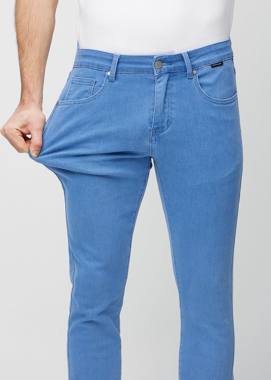 Modell strekker jeansene ved låret for å vise materialets stretch.