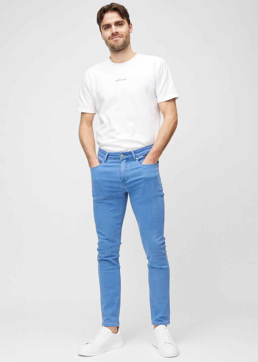 Helbilde av en modell i blå jeans i slim fit.