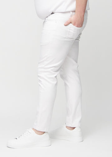 Hvite jeans i slim fit sett fra siden på en plus-size-modell.