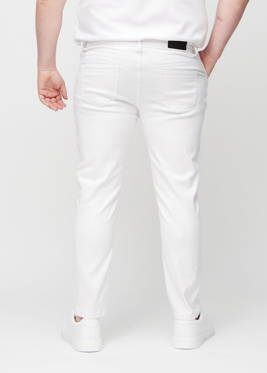 Hvite jeans i slim fit sett bakfra på en plus-size-modell for å vise hele produktet.