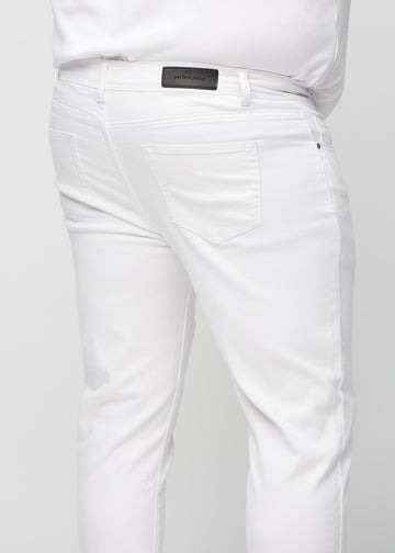 Nærbilde bakfra av hvite jeans i slim fit på en plus-size-modell som viser detaljer.