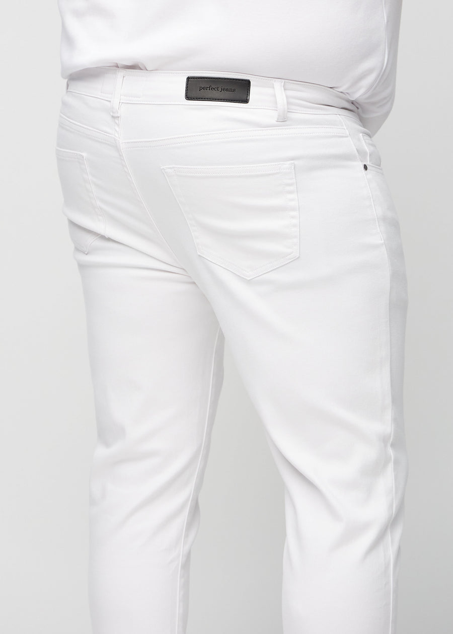 Nærbilde bakfra av hvite jeans i slim fit på en plus-size-modell som viser detaljer.