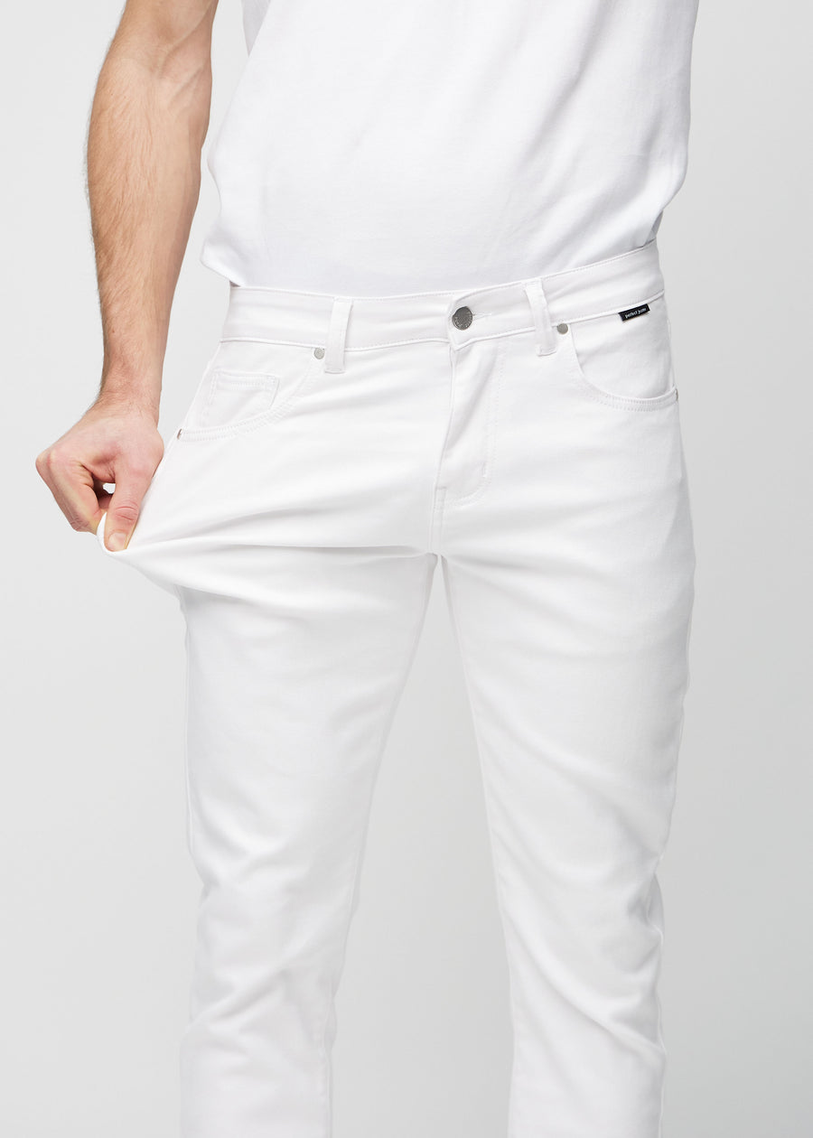 Modell strekker jeansene ved låret for å vise materialets stretch.