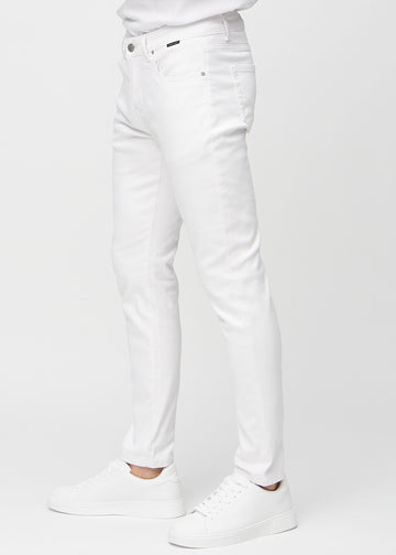 Hvite jeans i slim fit sett fra siden på en modell.