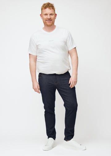 Fullt bilde av plus-size-modell i dyp mørkeblå denim jeans til menn i fargen Midnights med slim passform.