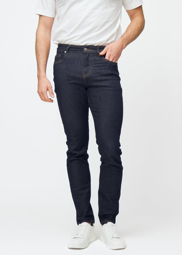 Dyp mørkeblå denim jeans til menn i fargen Midnights med slim passform, som sitter naturlig ved hoften og følger bena tettere, sett forfra.