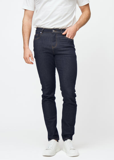 Dyp mørkeblå denim jeans til menn i fargen Midnights med slim passform, som sitter naturlig ved hoften og følger bena tettere, sett forfra.