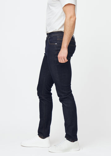 Dyp mørkeblå denim jeans til menn i fargen Midnights med slim passform sett fra siden på modell.