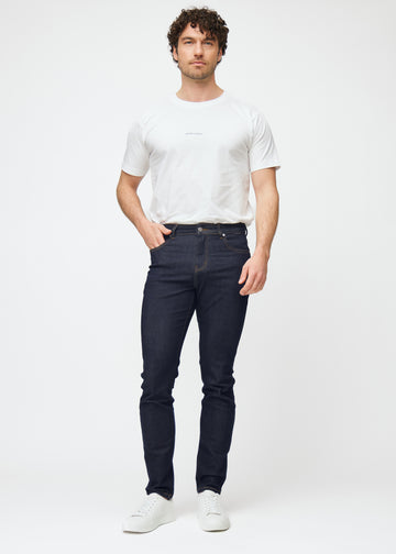 Fullt bilde av modell i dyp mørkeblå denim jeans til menn i fargen Midnights med slim passform.