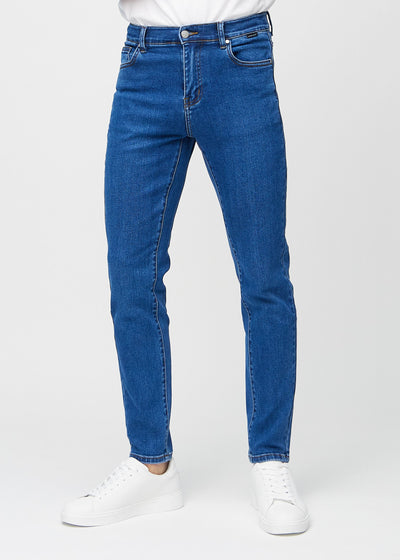 Mørkeblå denimjeans i slim fit, modellnavn Oceans, som sitter tett langs bena , sett forfra.