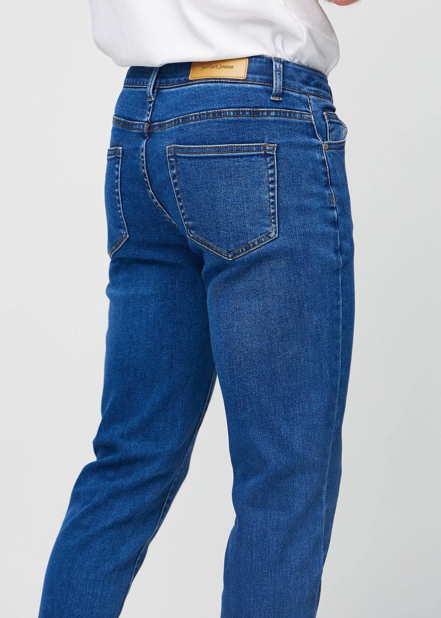 Nærbilde bakfra av mørkeblå denimjeans i slim fit som viser detaljer.