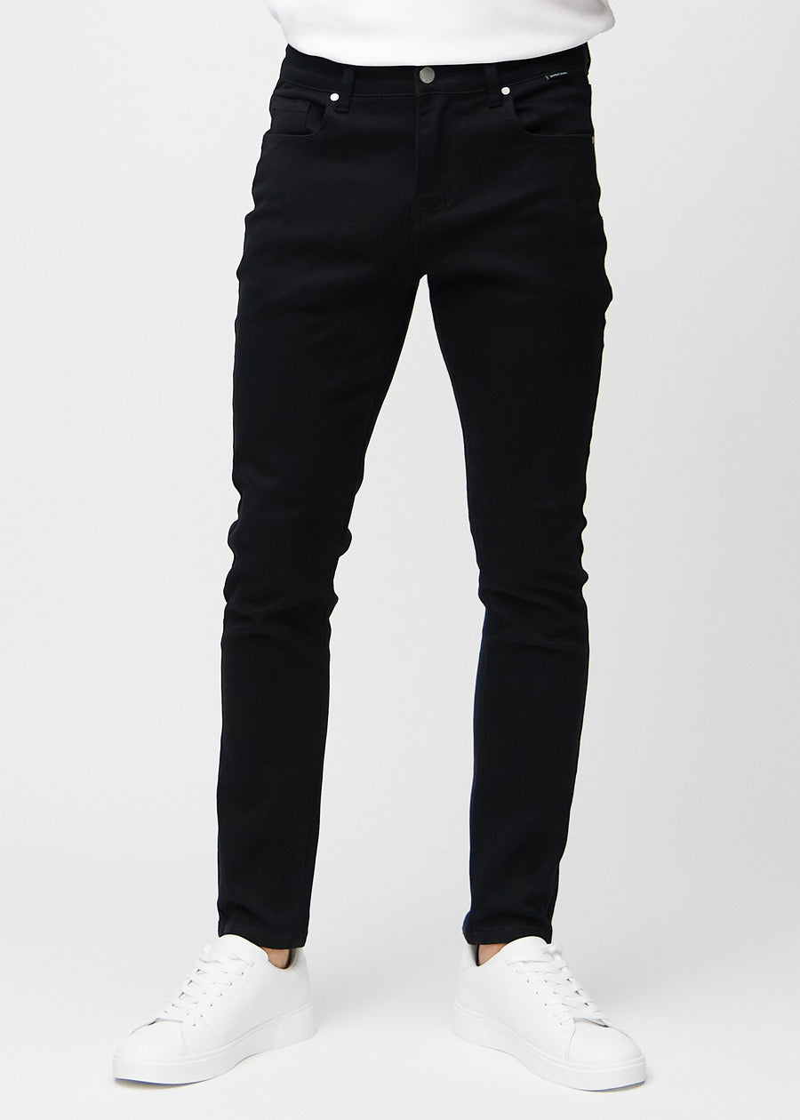 Svarte jeans i slim fit, modellnavn Ravens, som sitter tett langs bena, sett forfra.
