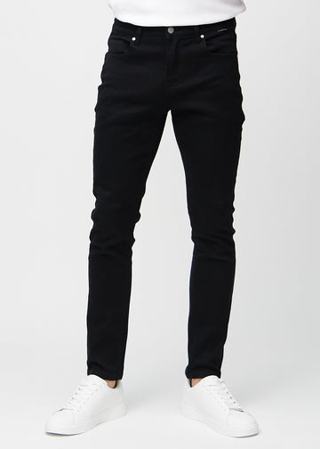 Svarte jeans i slim fit, modellnavn Ravens, som sitter tett langs bena, sett forfra.