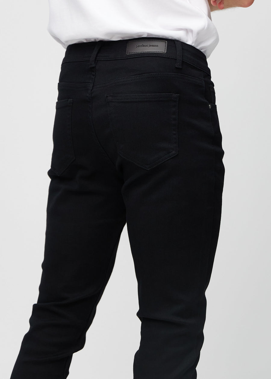 Nærbilde bakfra av svarte jeans i slim fit som viser detaljer.