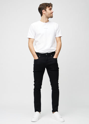 Helbilde av en modell i svarte jeans i slim fit.