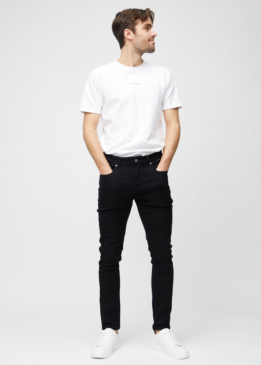 Helbilde av en modell i svarte jeans i slim fit.