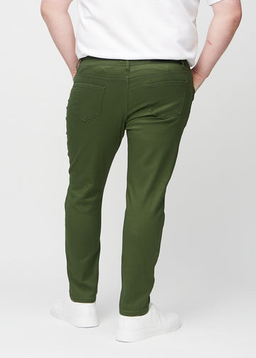 Mørkegrønne jeans i slim fit sett bakfra på en plus-size-modell for å vise hele produktet.