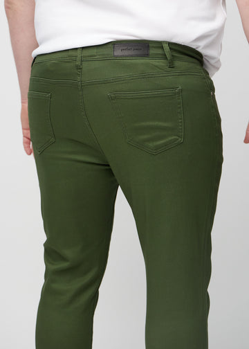 Nærbilde bakfra av mørkegrønne jeans i slim fit på en plus-size-modell som viser detaljer.