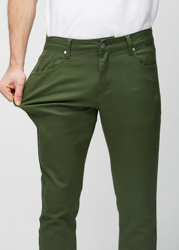 Modell strekker jeansene ved låret for å vise materialets stretch.