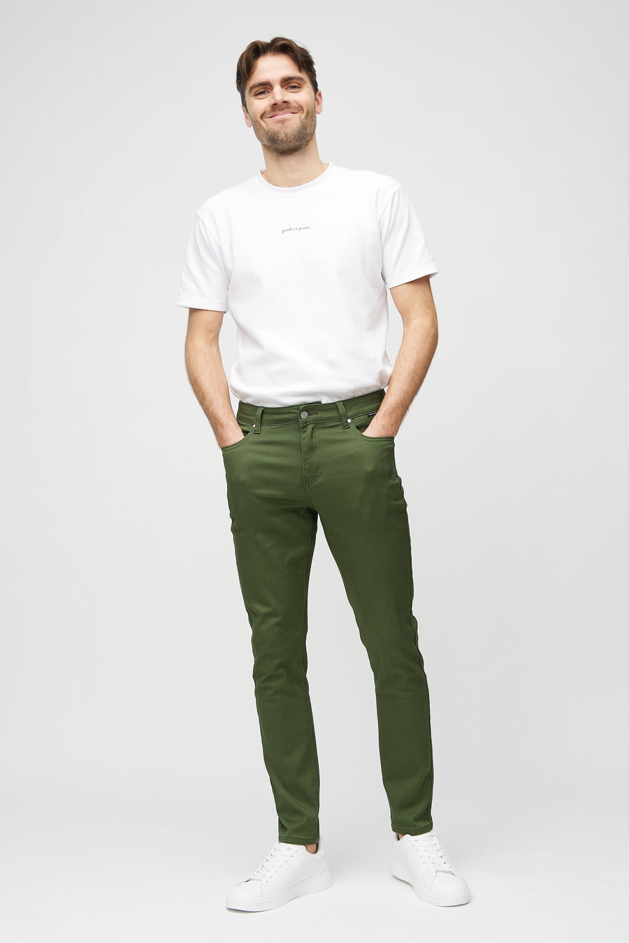 Helbilde av en modell i mørkegrønne jeans i slim fit.