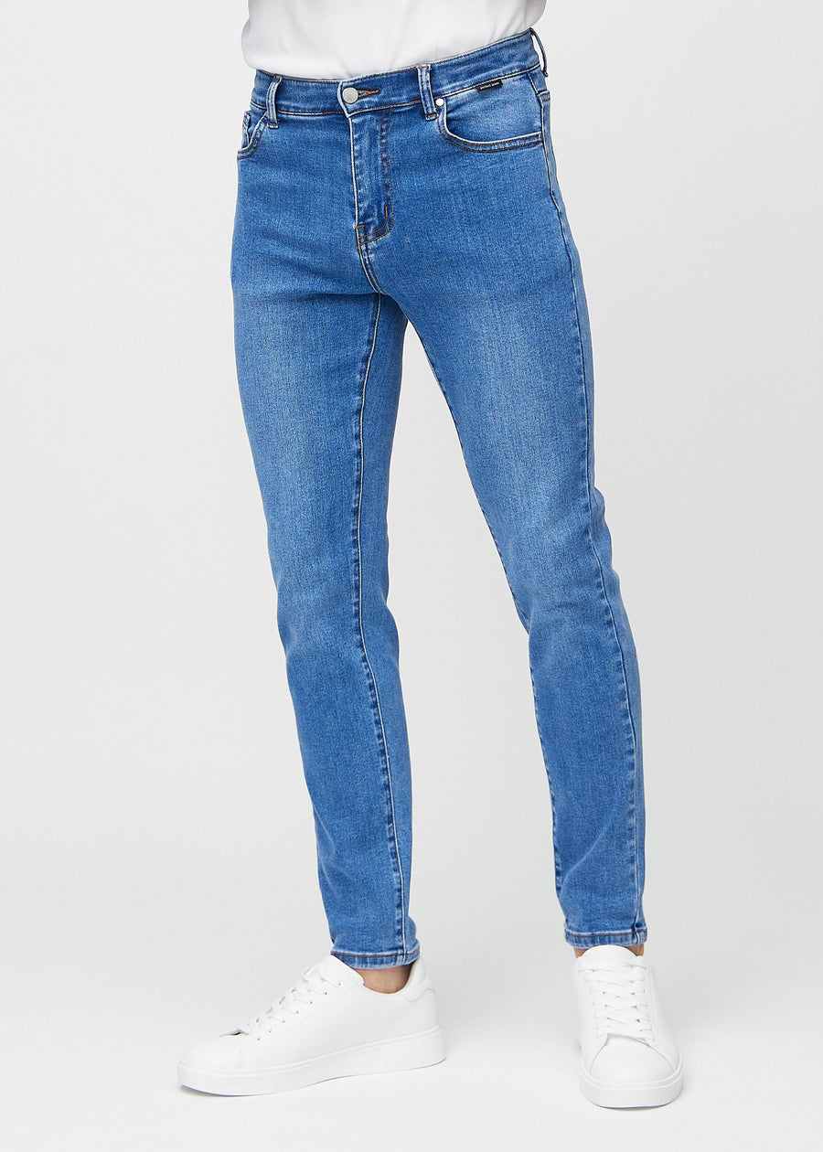 Blå denimjeans i slim fit, modellnavn Rivers, som sitter tett langs bena , sett forfra.