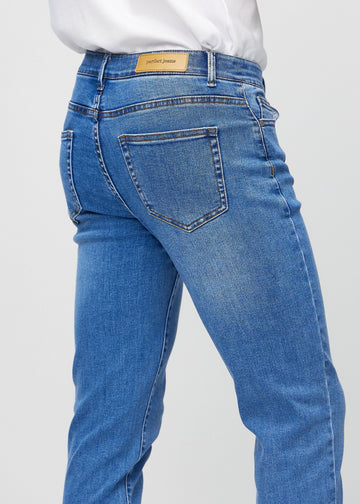 Nærbilde bakfra av blå denimjeans i slim fit som viser detaljer.