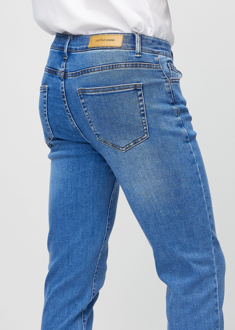Nærbilde bakfra av blå denimjeans i slim fit som viser detaljer.