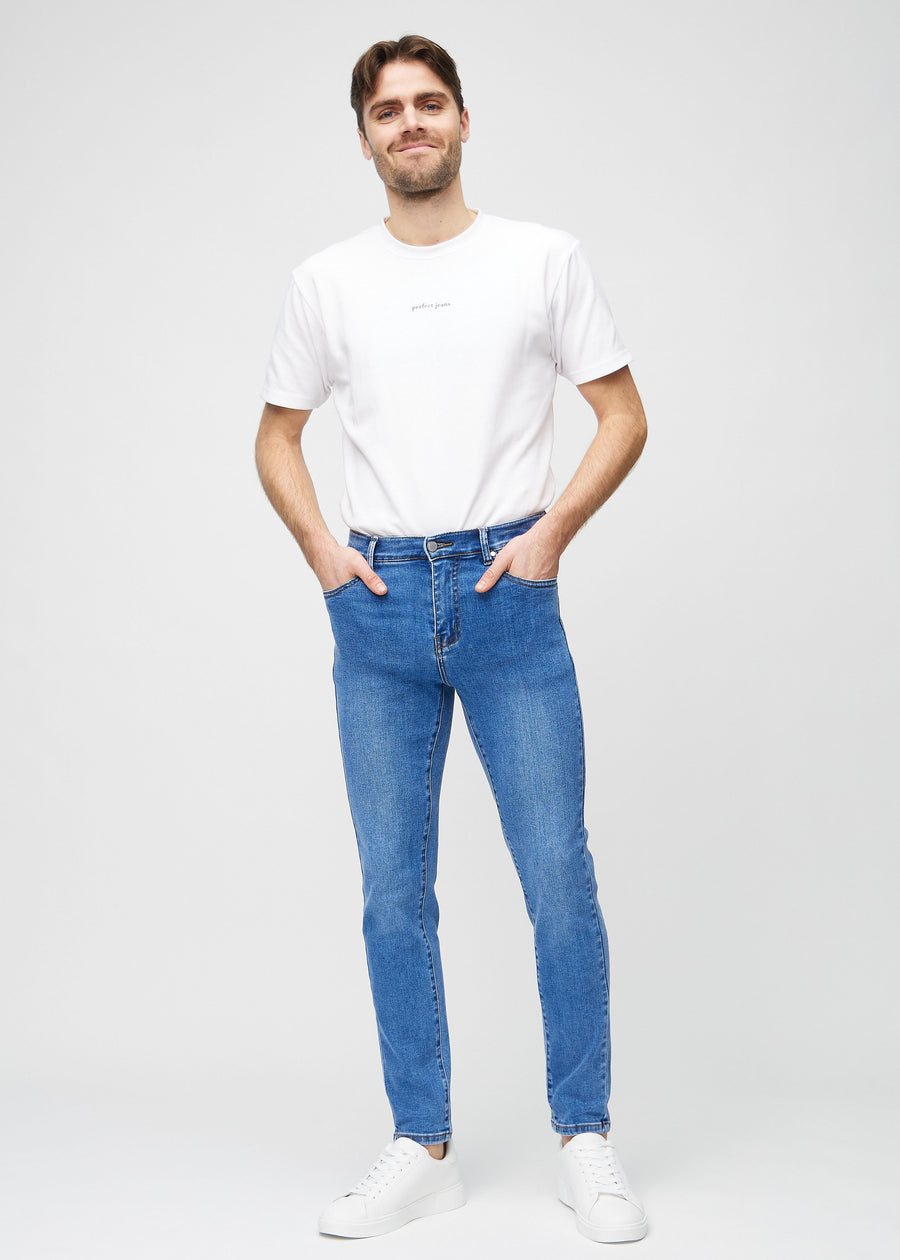 Helbilde av en modell i blå denimjeans i slim fit.