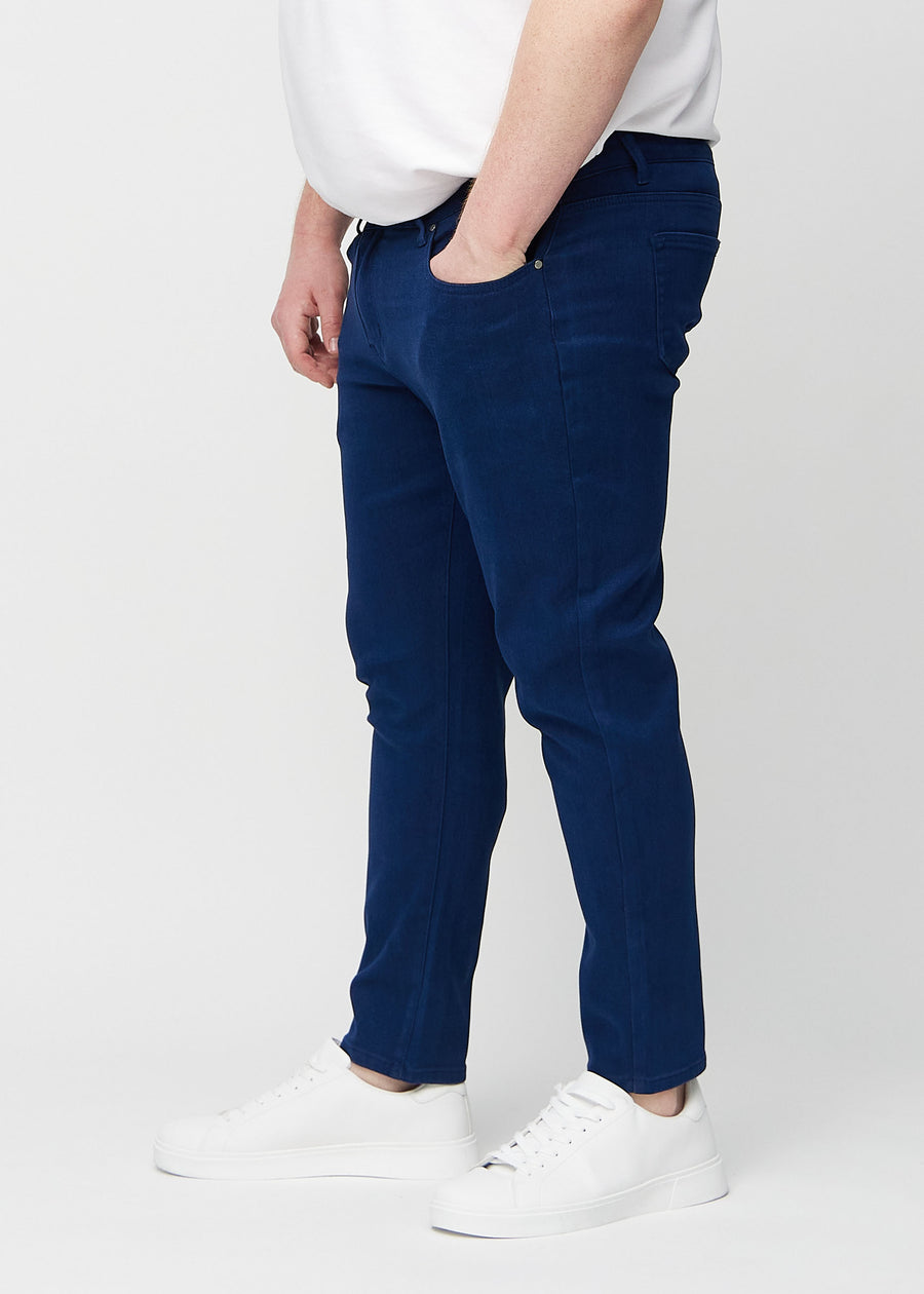 Mørkeblå jeans i slim fit sett fra siden på en plus-size-modell.