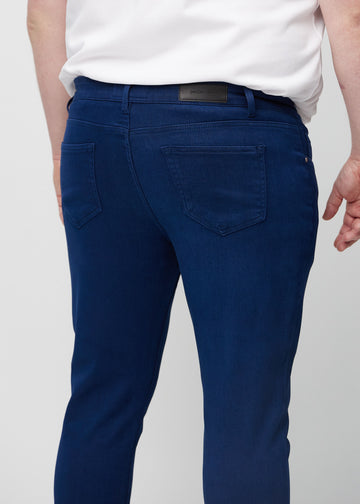 Nærbilde bakfra av mørkeblå jeans i slim fit på en plus-size-modell som viser detaljer.