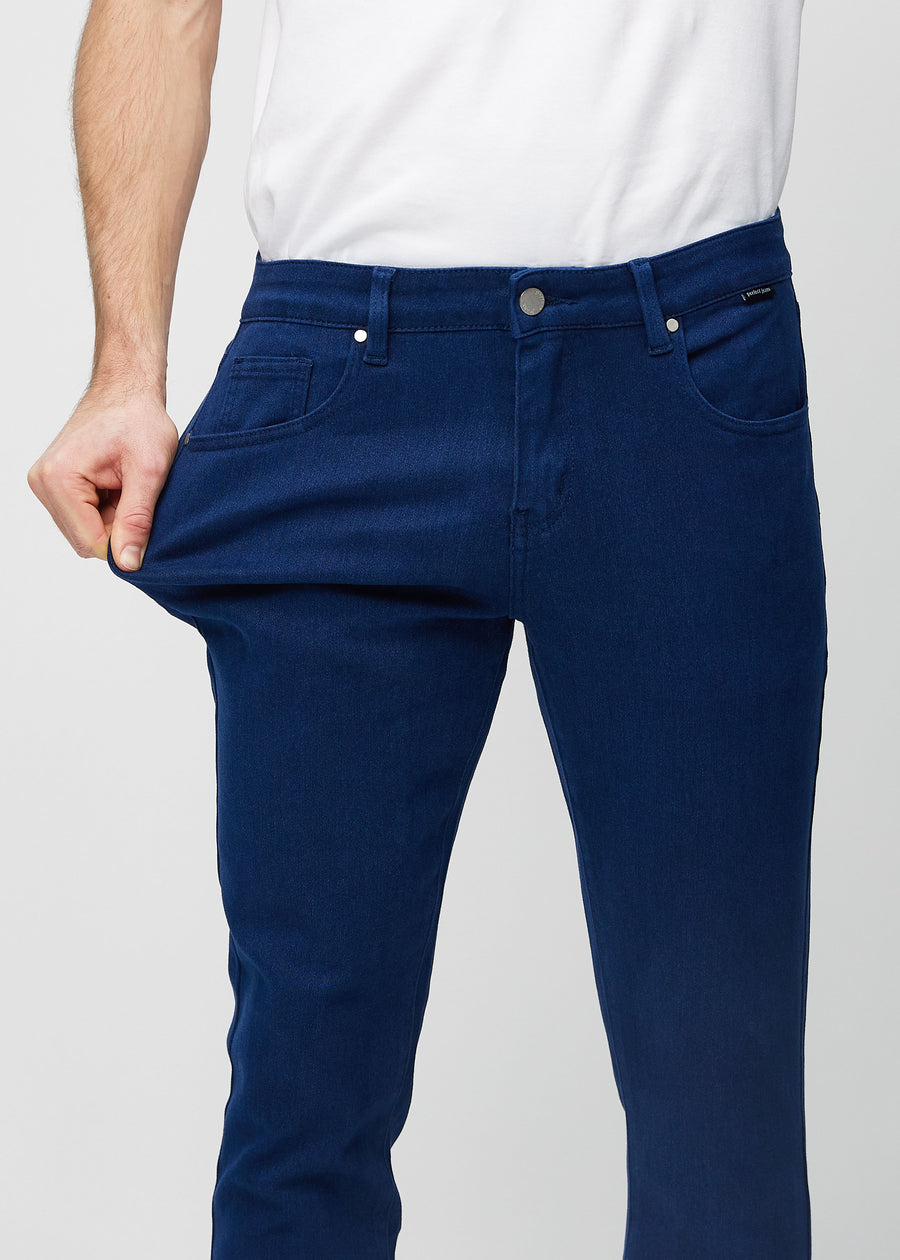 Modell strekker jeansene ved låret for å vise materialets stretch.