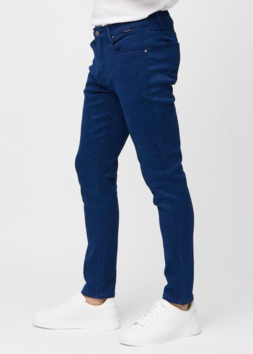 Mørkeblå jeans i slim fit sett fra siden på en modell.