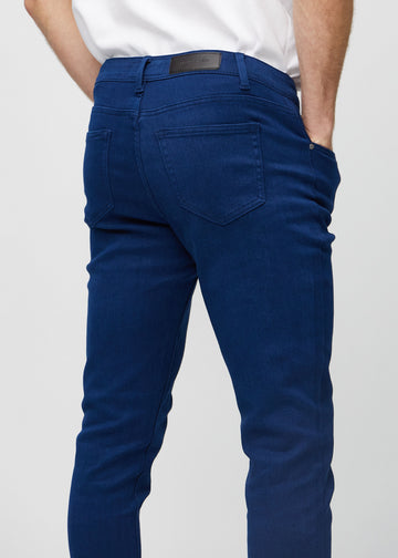 Nærbilde bakfra av mørkeblå jeans i slim fit som viser detaljer.