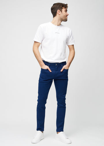 Helbilde av en modell i mørkeblå jeans i slim fit.
