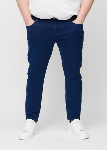 Mørkeblå jeans i slim fit, modellnavn Royals, som sitter tett langs bena på en plus-size-modell, sett forfra.