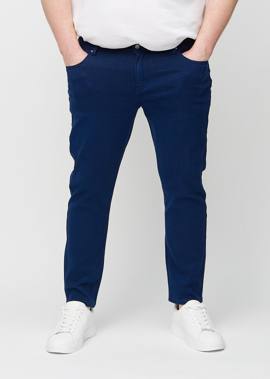 Mørkeblå jeans i slim fit, modellnavn Royals, som sitter tett langs bena på en plus-size-modell, sett forfra.