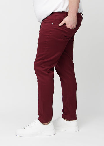 Mørkerøde jeans i slim fit sett fra siden på en plus-size-modell.