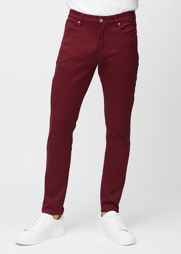 Mørkerøde jeans i slim fit, modellnavn Santas, som sitter tett langs bena, sett forfra.