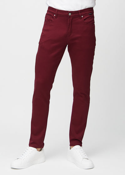 Mørkerøde jeans i slim fit, modellnavn Santas, som sitter tett langs bena, sett forfra.