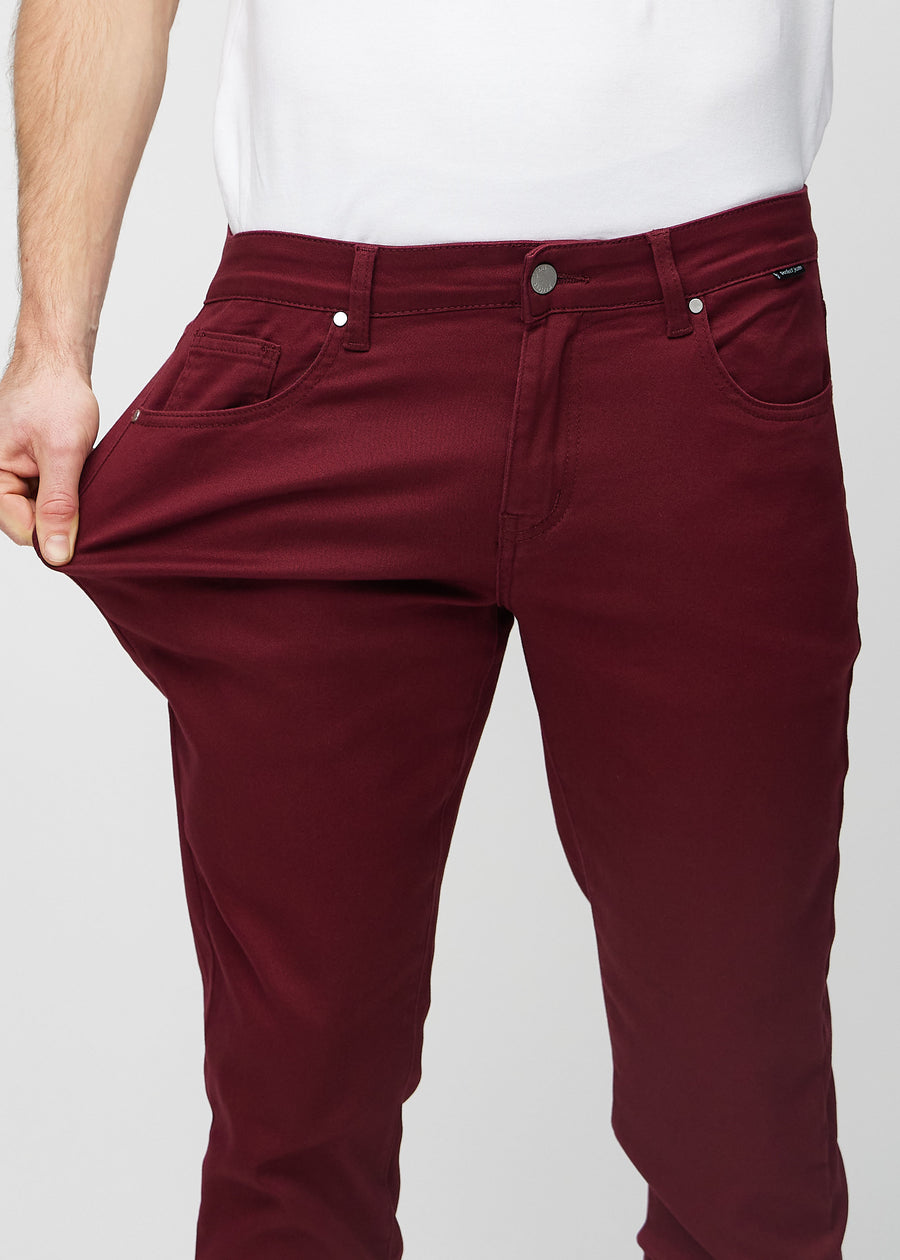 Modell strekker jeansene ved låret for å vise materialets stretch.