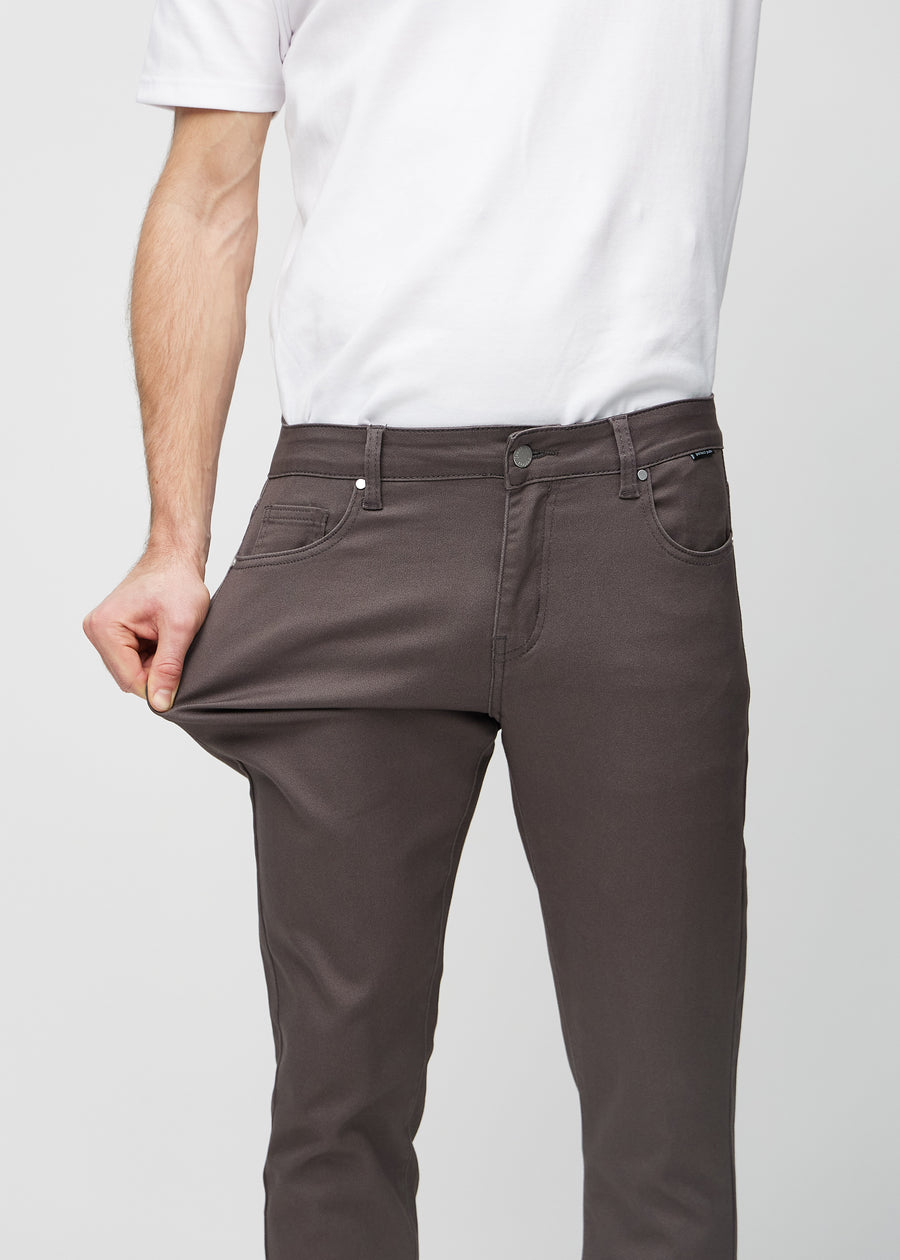 Modell strekker jeansene ved låret for å vise materialets stretch.