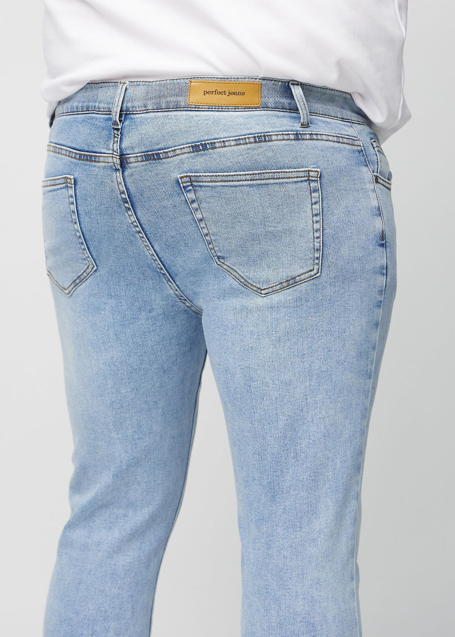 Nærbilde bakfra av lyseblå denimjeans i slim fit på en plus-size-modell som viser detaljer.