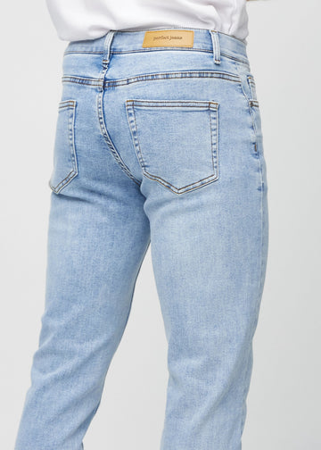 Nærbilde bakfra av lyseblå denimjeans i slim fit som viser detaljer.