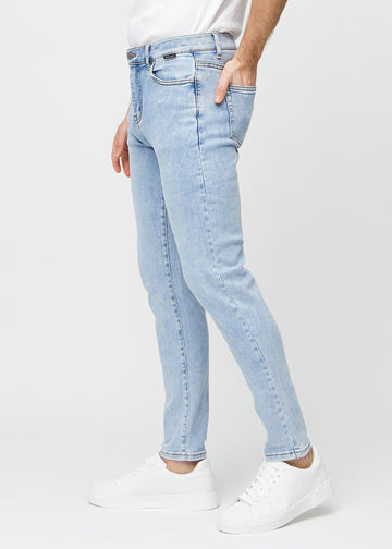 Lyseblå denimjeans i slim fit sett fra siden på en modell.