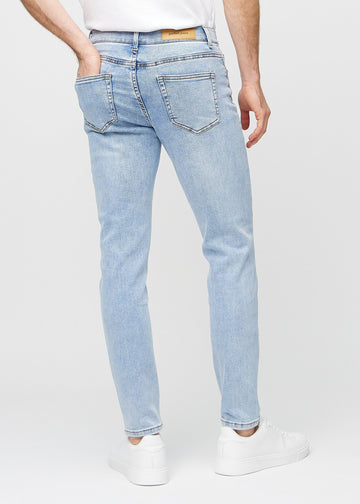 Lyseblå denimjeans i slim fit sett bakfra for å vise hele produktet.