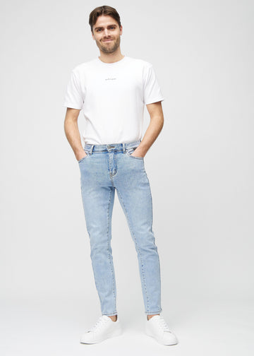 Helbilde av en modell i lyseblå denimjeans i slim fit.