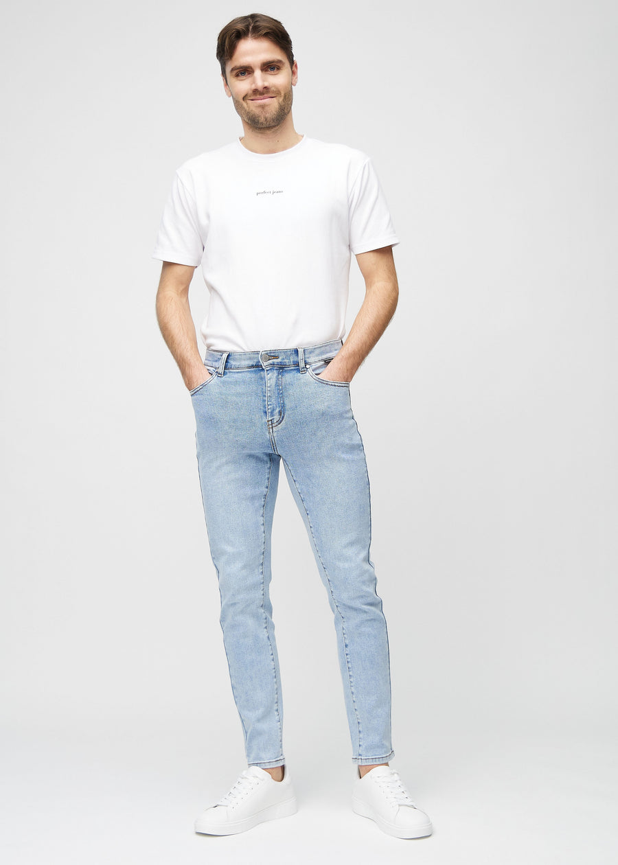 Helbilde av en modell i lyseblå denimjeans i slim fit.