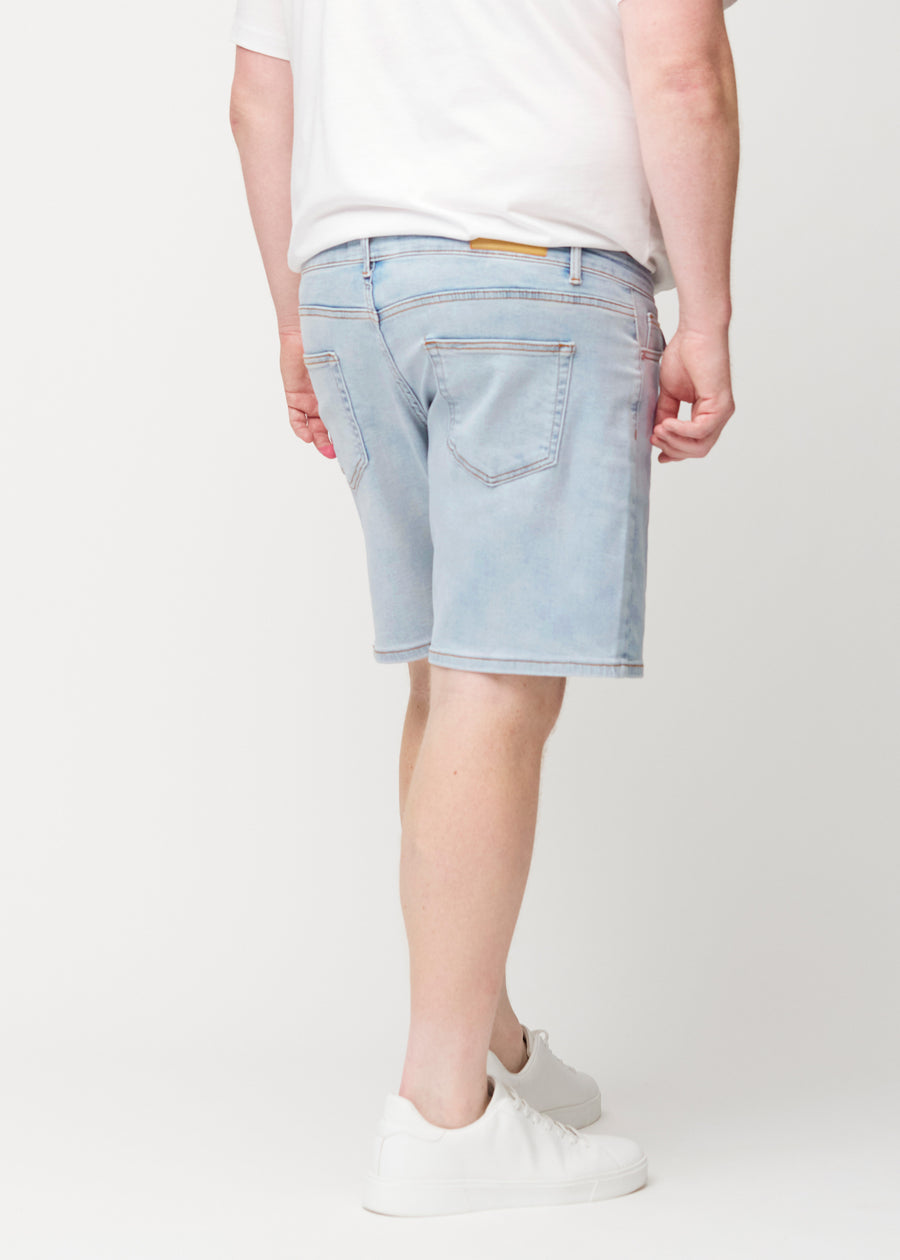 Lyseblå denimshorts til menn i fargen Waves sett bakfra på plus-size-modell, slik at lengden til rett over kneet kan ses.